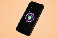 Смартфон с логотипом Android 17 на экране на оранжевом фоне