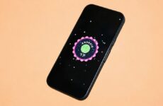 Смартфон с логотипом Android 17 на экране на оранжевом фоне