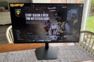 Монитор Samsung Odyssey 32G80HS на столе с открытым игровым меню Battlefield