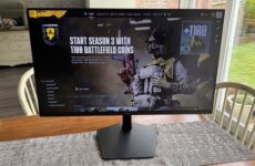 Монитор Samsung Odyssey 32G80HS на столе с открытым игровым меню Battlefield