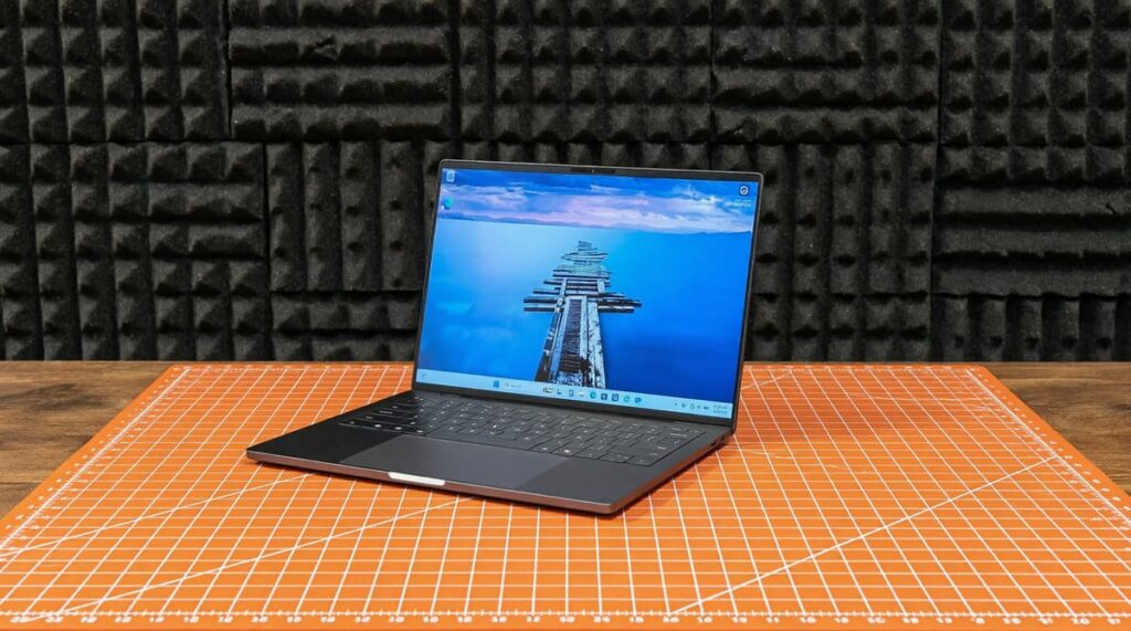 Dell XPS 14 2026 на оранжевом коврике с синим экраном