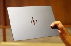 Закрытый ноутбук HP OmniBook Ultra 14 с логотипом на крышке в руке